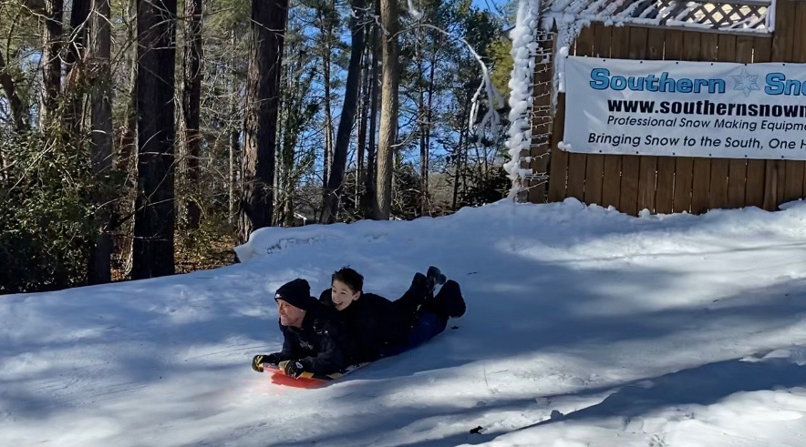 father and son sledding on snow